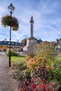 a monument in the middle of a park with flowers at Town Centre Apartment in Westport