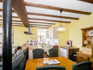 a kitchen and living room with a table and chairs at Lavender Cottage II in Scalby
