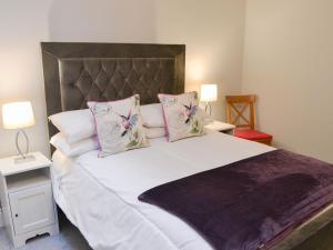 a bedroom with a large bed with white sheets and pillows at Morpeth Court in Morpeth