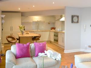 a living room with a couch and a kitchen at Morpeth Court in Morpeth