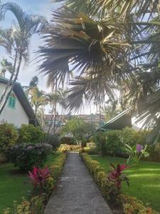 una pasarela frente a una casa con palmeras en Las Palmas Eco Residence en Las Terrenas