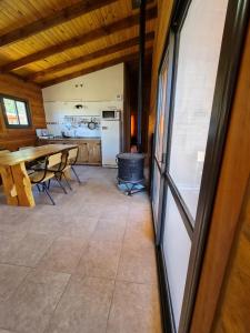 a kitchen and dining room with a table and a stove at CABAÑA PRIVADA NALÚ in Villa Ciudad Parque
