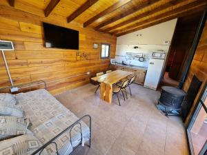 a dining room with a table and a kitchen at CABAÑA PRIVADA NALÚ in Villa Ciudad Parque +7 photos