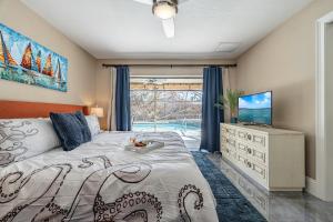 a bedroom with a bed and a tv and a window at Heated Pool, Sleeps 8 - Villa Sunny Daze in Cape Coral +44 photos