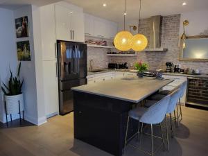 una cocina con una isla negra con taburetes de bar en Exclusive Townhome near West-Side Trails, en Waterloo