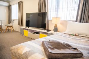 a bedroom with a bed with a television on it at Tarawera River Lodge Motel in Kawerau