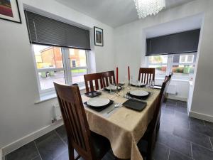 comedor con mesa, sillas y ventanas en Spacious 3-bed Luxury Maidstone Kent Home - Wi-Fi & Parking en Kent
