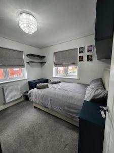 a bedroom with a bed and two windows at Spacious 3-bed Luxury Maidstone Kent Home - Wi-Fi & Parking in Kent