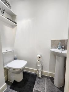 La salle de bains blanche est pourvue de toilettes et d'un lavabo. dans l'établissement Spacious 3-bed Luxury Maidstone Kent Home - Wi-Fi & Parking, à Kent