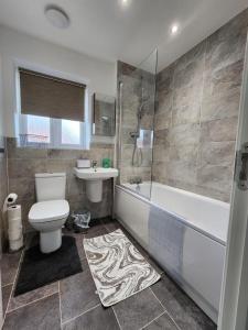a bathroom with a toilet and a tub and a sink at Spacious 3-bed Luxury Maidstone Kent Home - Wi-Fi & Parking in Kent