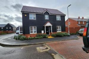 une maison noire sur le côté d'une rue dans l'établissement Spacious 3-bed Luxury Maidstone Kent Home - Wi-Fi & Parking, à Kent