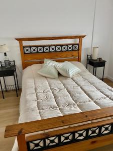 1 cama grande con 2 almohadas encima en Fontinalis Hosting Perla en Mar del Plata