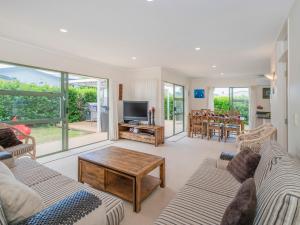 a living room with two couches and a television at Beach Beauty - Pauanui Holiday Home in Pauanui