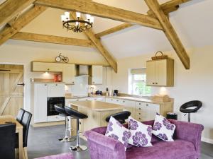 a kitchen and living room with a purple couch at Y Bwythyn in Tavernspite