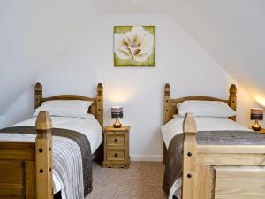 two twin beds in a bedroom with a picture on the wall at Y Bwythyn in Tavernspite