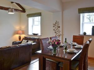 a living room with a table and a couch at Manor Farm Cottage in Carperby