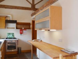 a kitchen with a wooden counter top in a room at Barn Owl Cottage in Cromford