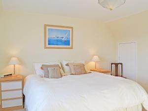 a bedroom with a large white bed with two lamps at Dinsel in Upton