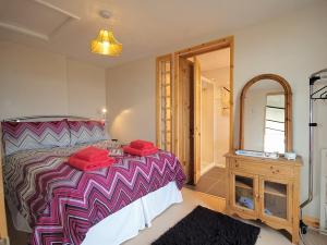 a bedroom with a large bed and a mirror at Les Quatre Vents in Dungeness
