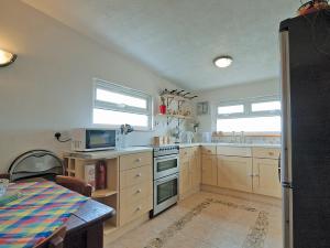 a kitchen with a sink and a stove top oven at Les Quatre Vents in Dungeness