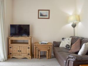 a living room with a couch and a table with a tv at West View in Bowness-on-Windermere