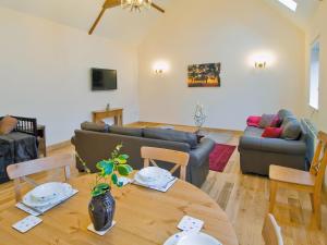 ein Wohnzimmer mit einem Tisch und einem Sofa in der Unterkunft Dairy Cottage - E5279 in Shincliffe