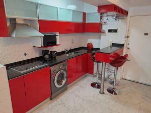 cocina con armarios rojos y lavadora en Departamento de Lujo en la Ciudad Buenos Aires en Buenos Aires