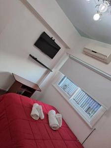 1 dormitorio con 1 cama roja y 2 zapatillas blancas en Departamento de Lujo en la Ciudad Buenos Aires en Buenos Aires