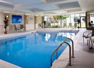 a pool in a hotel with chairs and a table at Waterfront Hotel Downtown Burlington in Burlington