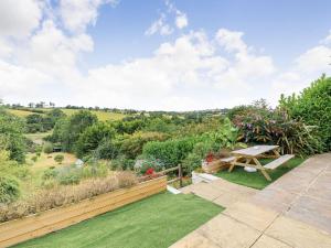 a garden with a bench and a view of the countryside at West Brae in Bishops Tawton