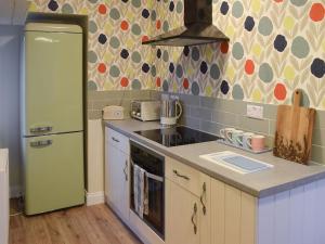 a kitchen with a green refrigerator and a stove at Gable End Cottage in Goathland