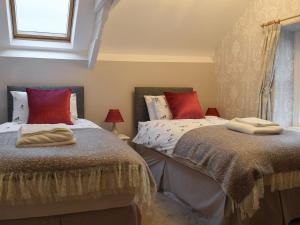 two beds sitting next to each other in a bedroom at Gable End Cottage in Goathland