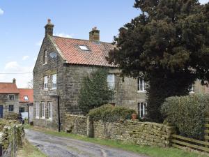 an old stone house on a dirt road at Gable End Cottage in Goathland