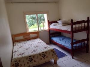 1 dormitorio con 2 literas y ventana en casa a uma quadra do mar, en Torres