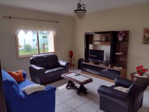 sala de estar con sofás y TV en casa a uma quadra do mar, en Torres
