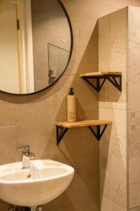 y baño con lavabo y espejo. en Boetiek hotel Azul, en Goedereede