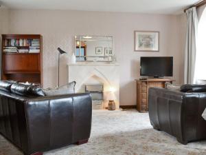 a living room with two leather chairs and a fireplace at The Old Chapel in Hury