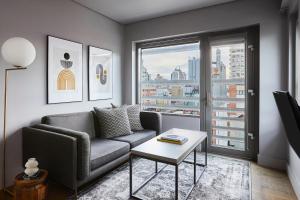 a living room with a couch and a table and a window at Kasa Lantern Lower East Side in New York