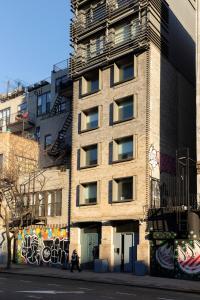 a building with graffiti on the side of it at Kasa Lantern Lower East Side in New York