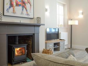 ein Wohnzimmer mit einem Kamin und einem TV in der Unterkunft The Station House in Upper Poppleton