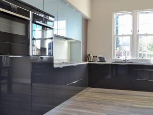 uma cozinha com armários pretos e um lavatório em The Station House em Upper Poppleton