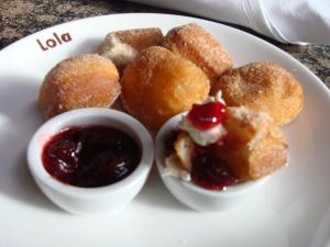 a white plate topped with donuts and dipping sauce at Hotel Ändra in Seattle
