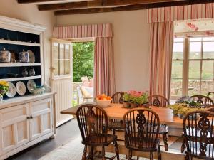 a dining room with a wooden table and chairs at Warren Farmhouse in Kildale