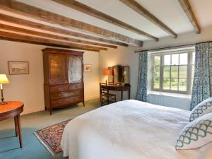 sypialnia z łóżkiem, komodą i oknem w obiekcie Warren Farmhouse w mieście Kildale