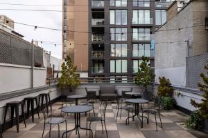 uma varanda com mesas e cadeiras num edifício em Kasa Lantern Lower East Side em Nova Iorque