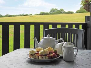 a plate of food on a table with a tea kettle at Foxglove Lodge - Uk13448 in Halwill