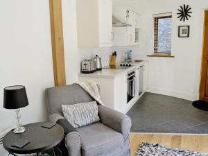 a living room with a chair and a table at Poppys Footprint in Middleham