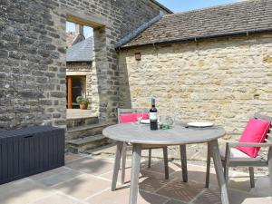 a patio with a table and two chairs and a bottle of wine at Poppys Footprint in Middleham