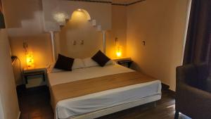 a bedroom with a large bed with two night stands at Hotel y Restaurant Puesta del Sol in Ocotlán
