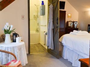 a room with a bed and a shower and a table at Myrtle Loft in Instow